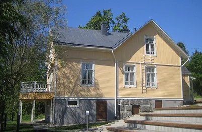 Huvila Koivurannan vaaleankeltainen puujulkisivu ja pihaterassi